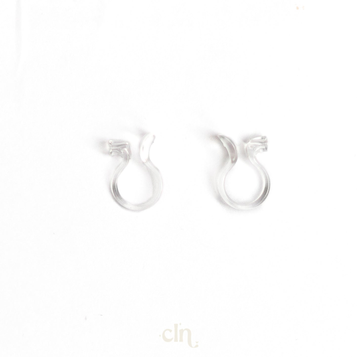 a pair of silver earrings on a white background