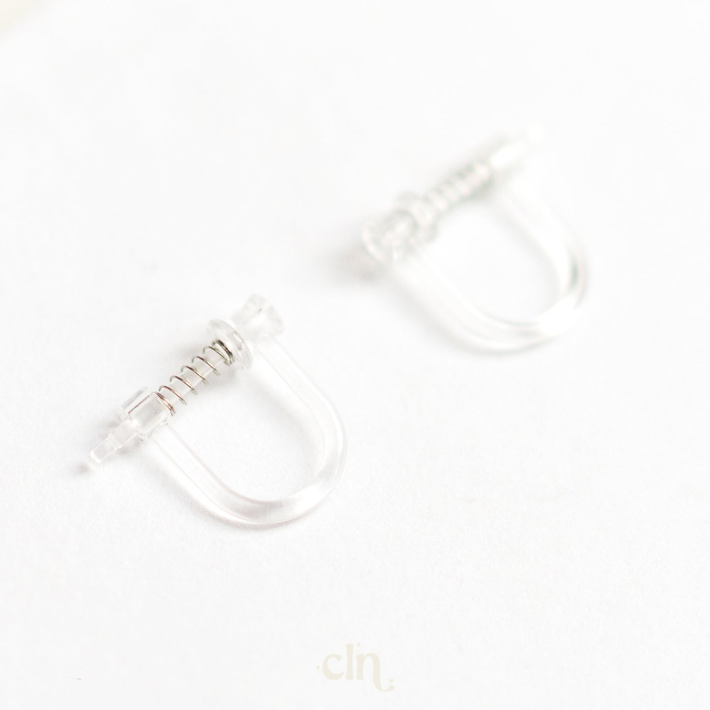 a pair of clear rings sitting on top of a white surface