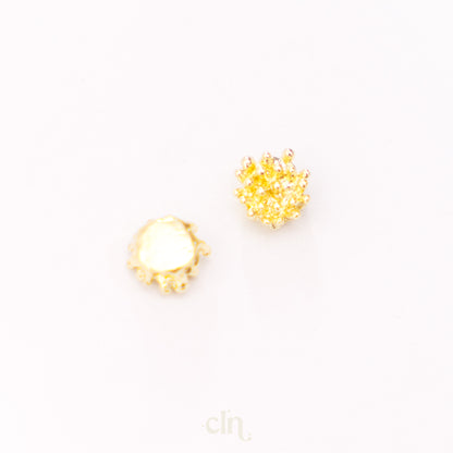 a pair of yellow and white earrings on a white surface