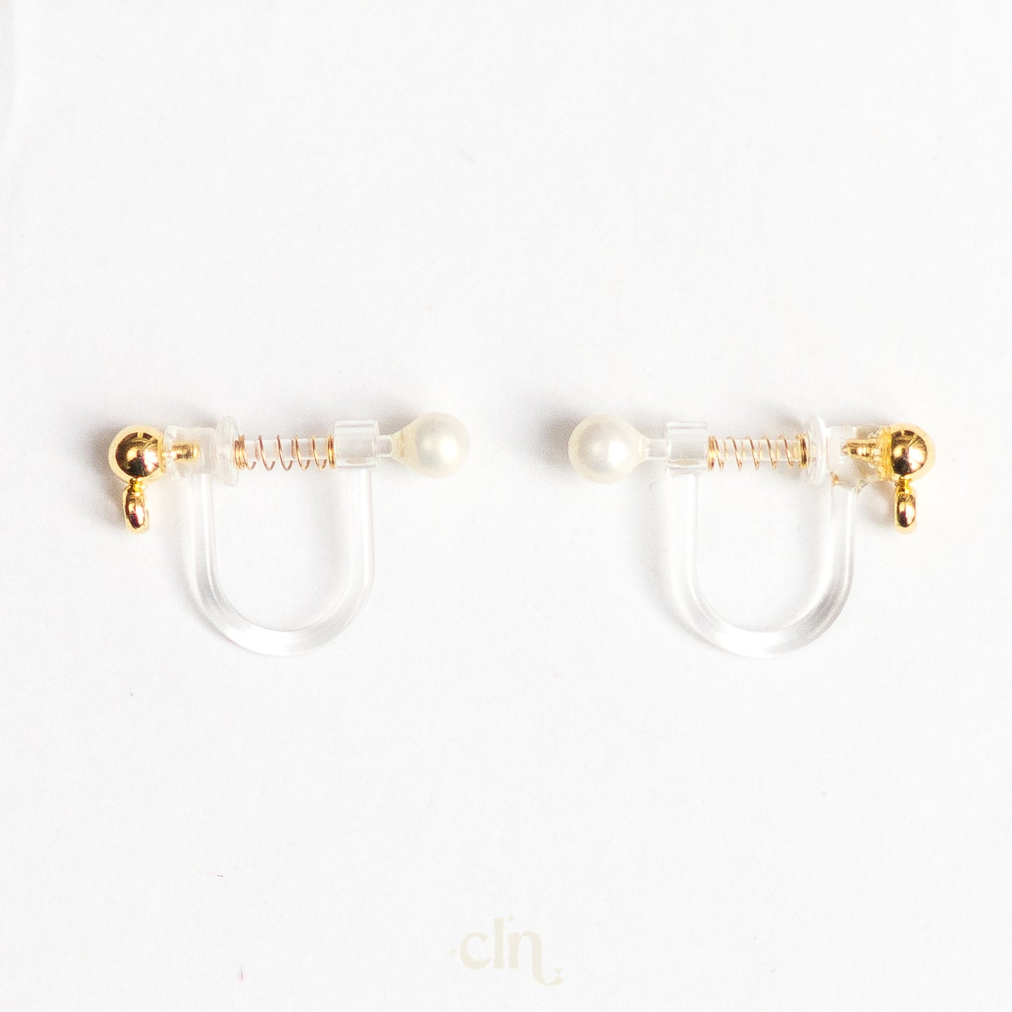 a pair of gold and pearl earrings on a white background