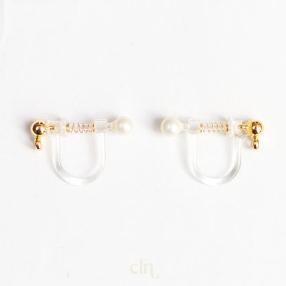 a pair of gold and pearl earrings on a white background