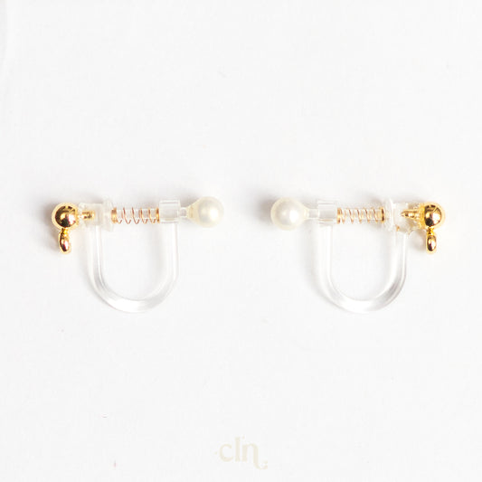 a pair of gold and pearl earrings on a white background