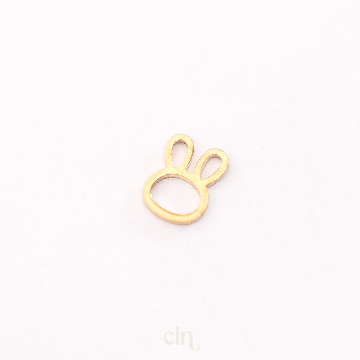 a gold plated charm with a rabbit's paw on it