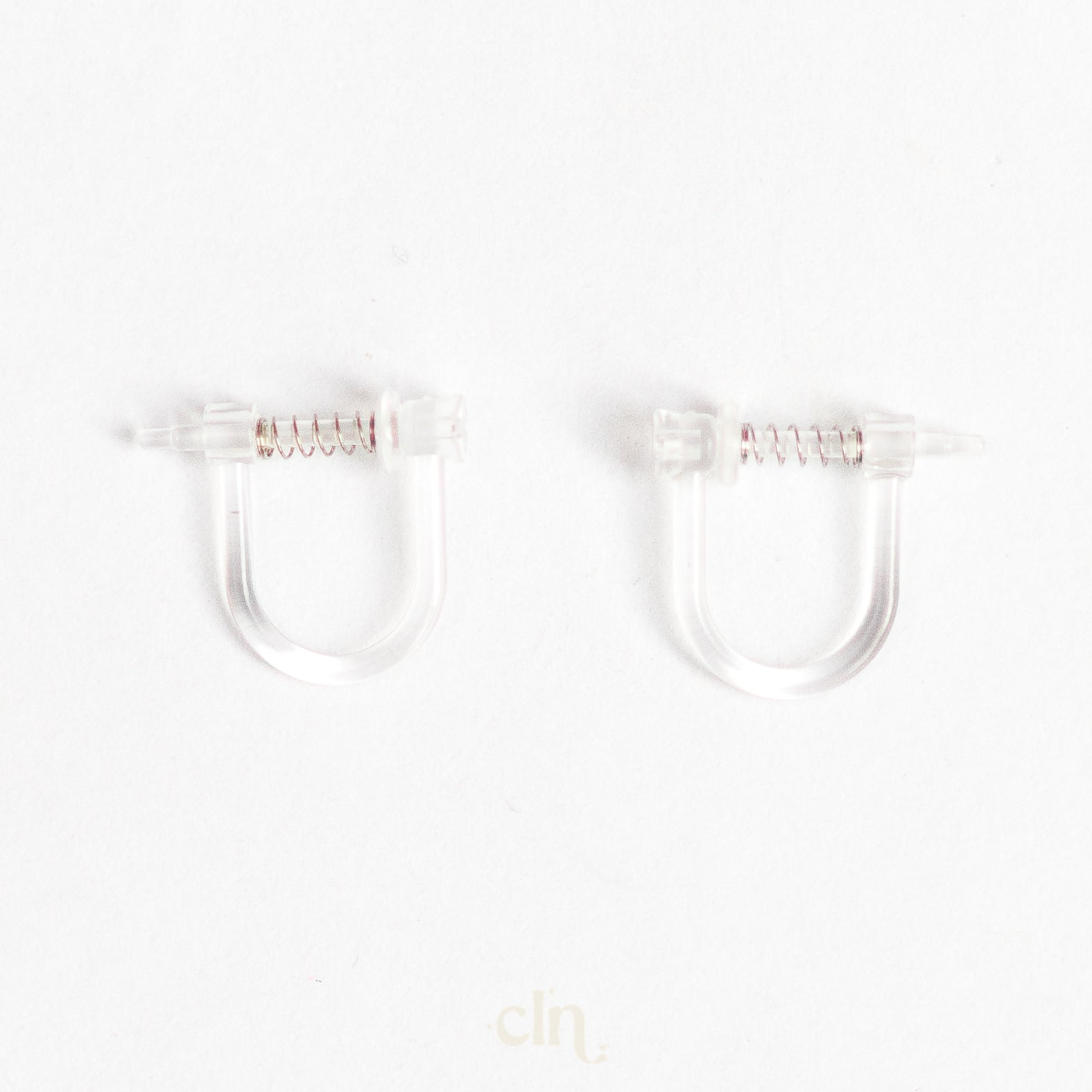 a pair of clear plastic ear clips on a white background