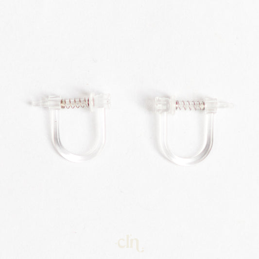 a pair of clear plastic ear clips on a white background