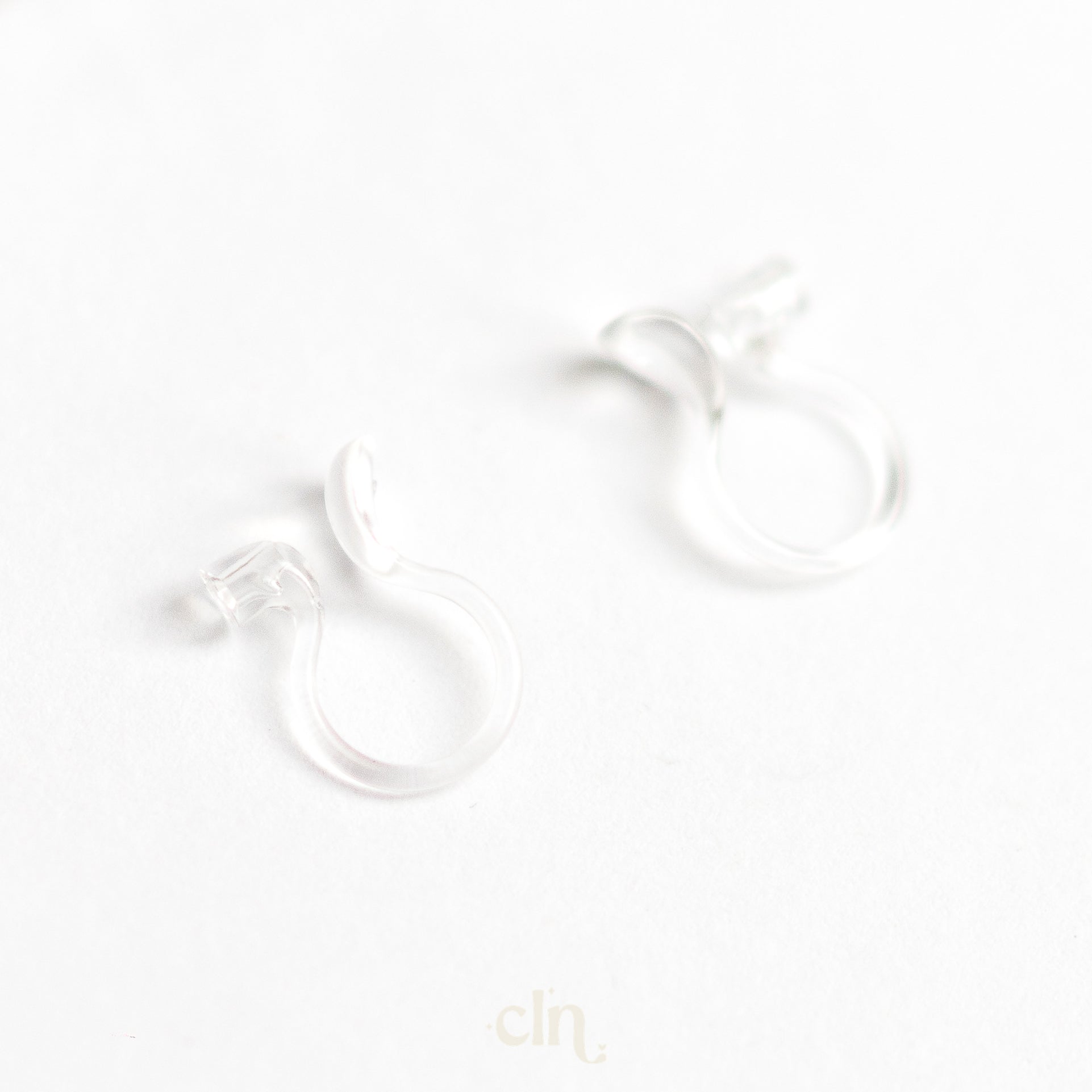 a pair of earrings sitting on top of a white surface